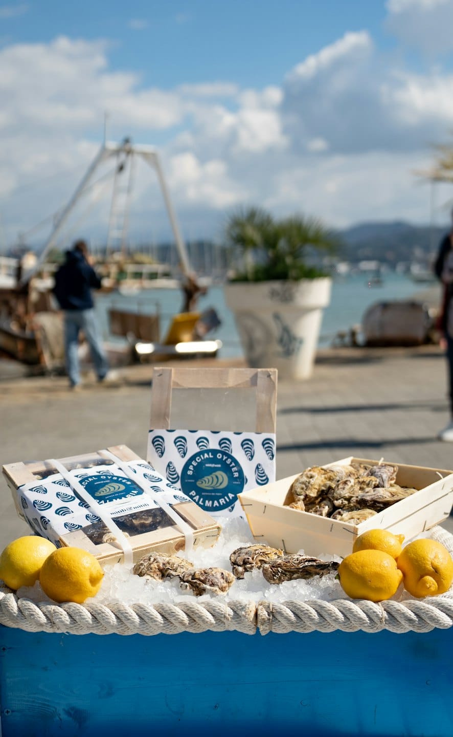 Fresh oysters and lemons displayed on a weathered wooden crate.
