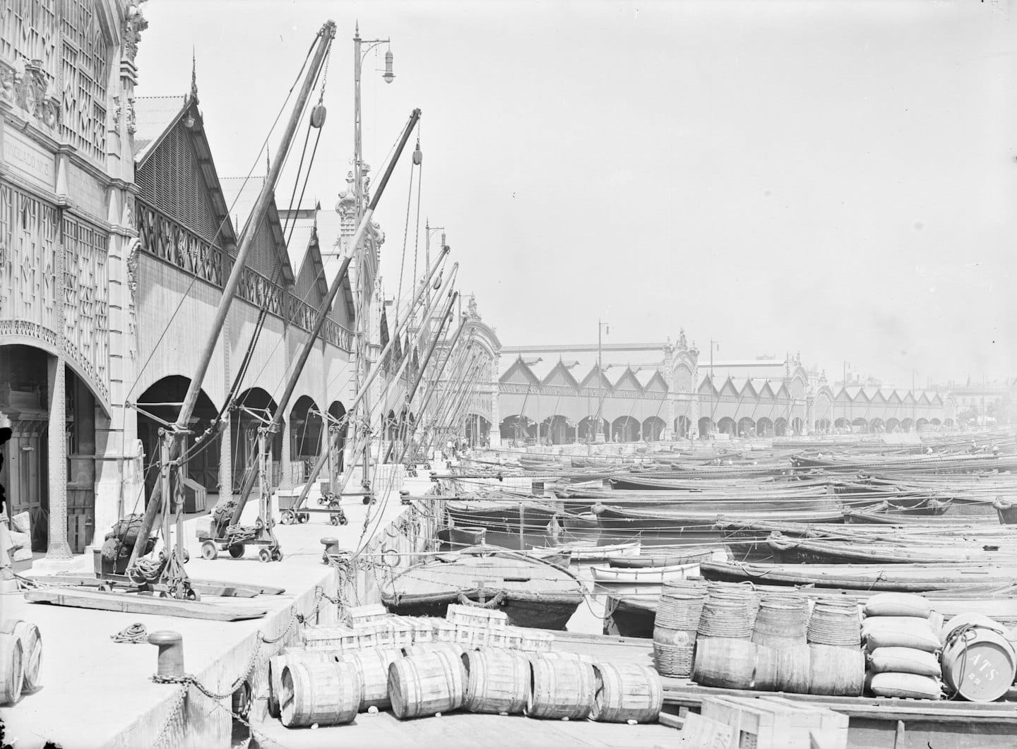 Wooden boats dock at a historical port beside an ornate building.
